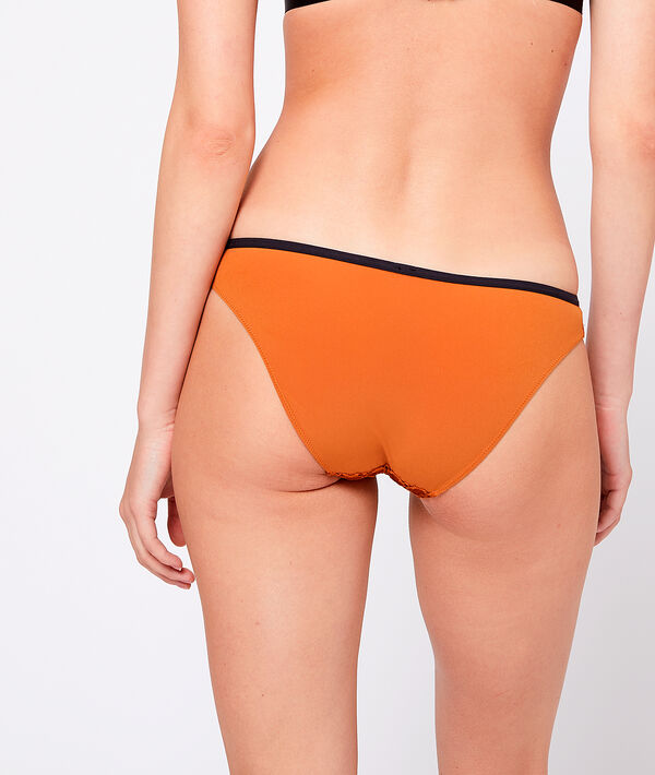 Culotte en dentelle texturée, détail oeillet ocre.