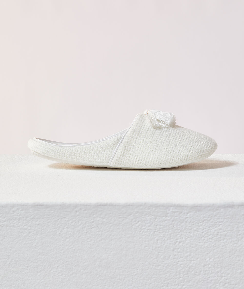 Chaussons mules à pompons beige.