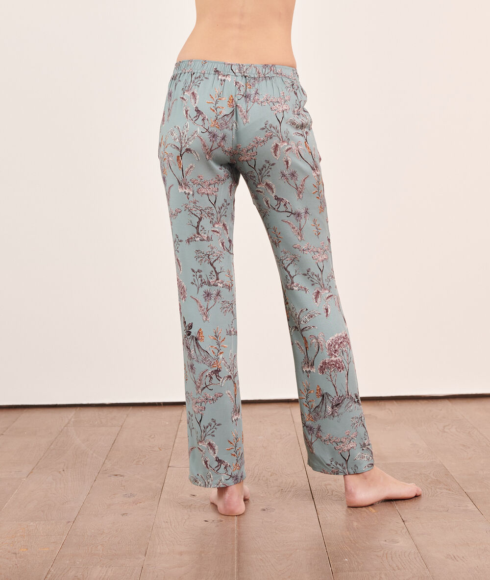 Pantalon imprimé paysage fond vert.