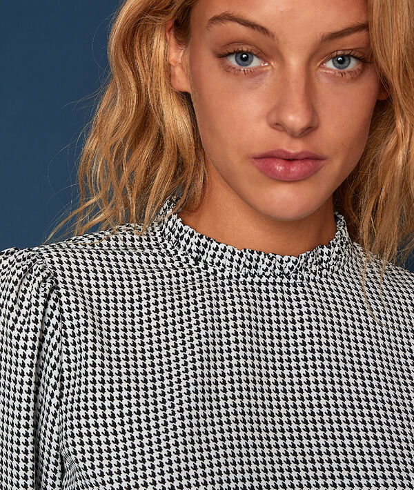 Blouse à carreaux manches resserrées noir et blanc.