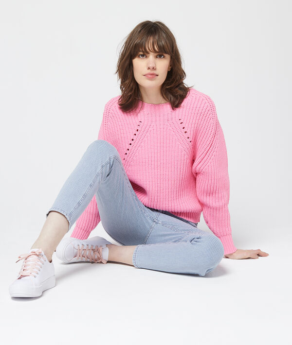 Pull en grosse maille rose pale.