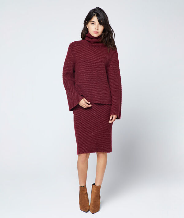 Jupe crayon en grosse maille bordeaux.