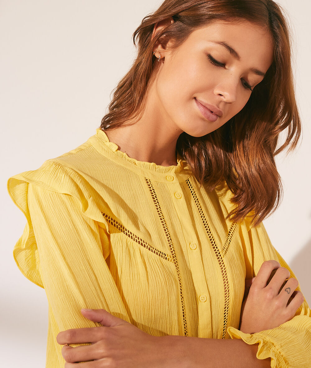 Chemise à volants avec détails en dentelle jaune pale.