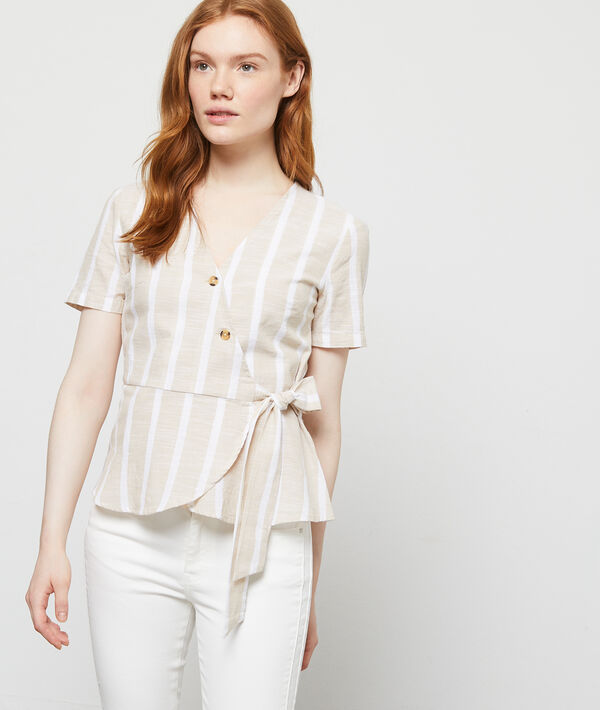 Blouse cache-coeur en coton beige.