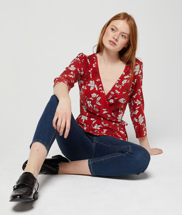 Blouse cache-coeur à imprimé floral rouge.