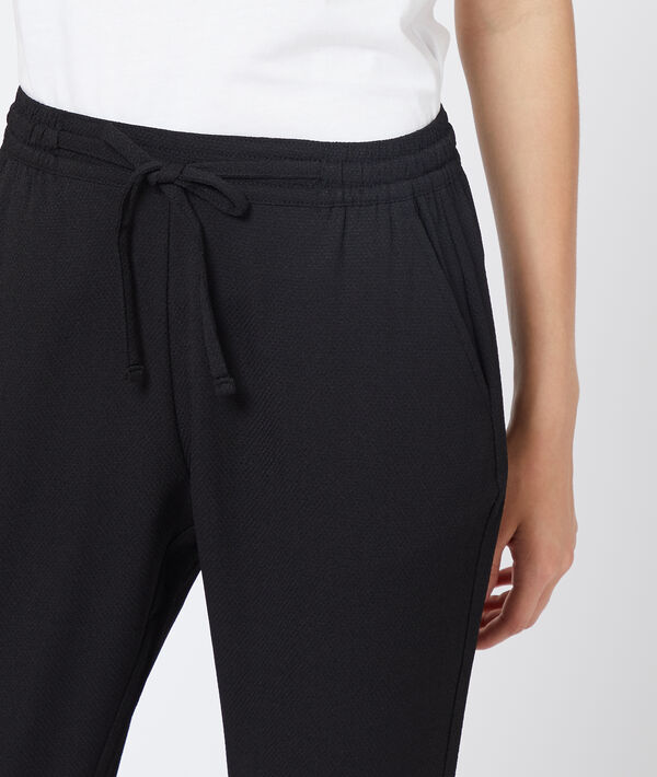 Pantalon carotte ceinturé noir.