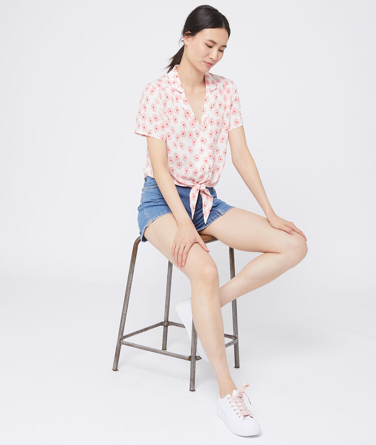 Chemisier noué à imprimé fleuri rose pale.