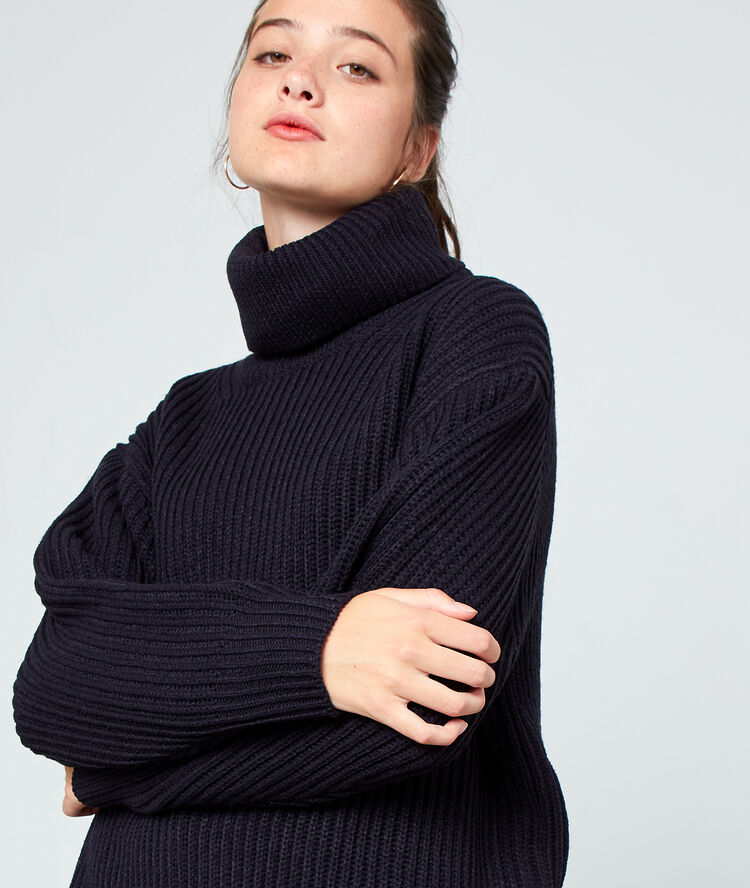 Pull col roulé en grosse maille marine.