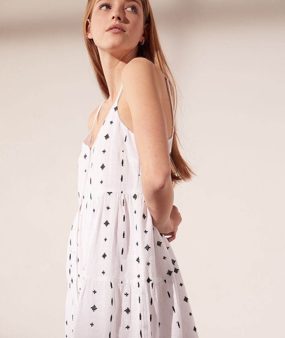 Robe à bretelles fines motifs brodés blanc.