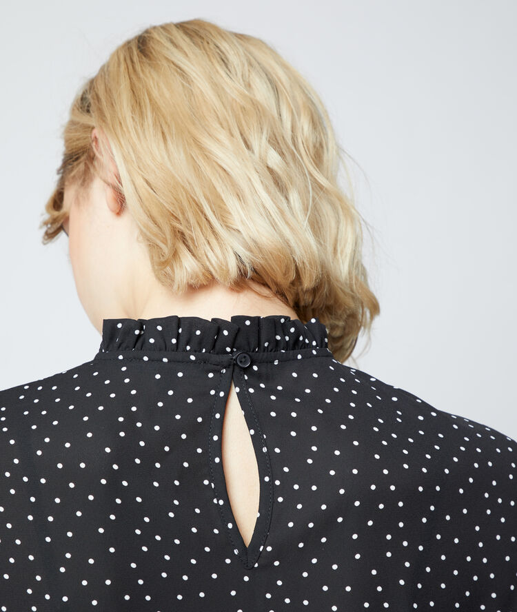Blouse à pois noir.