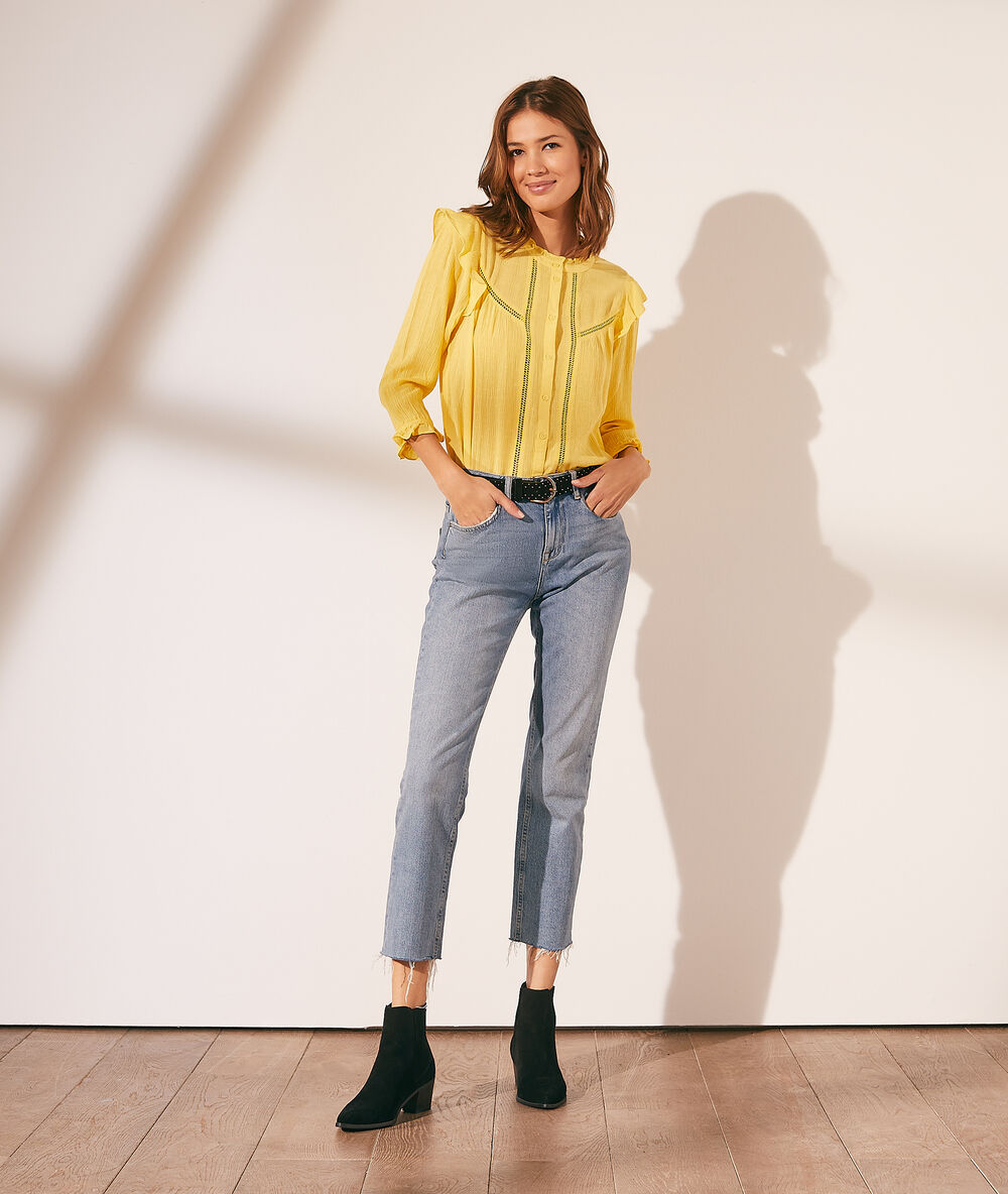 Chemise à volants avec détails en dentelle jaune pale.