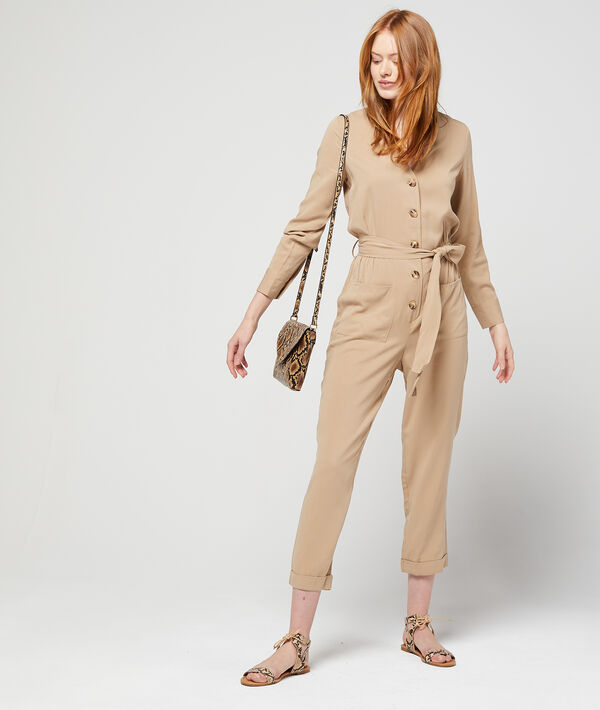 Combinaison ceinturée et boutonnée beige.