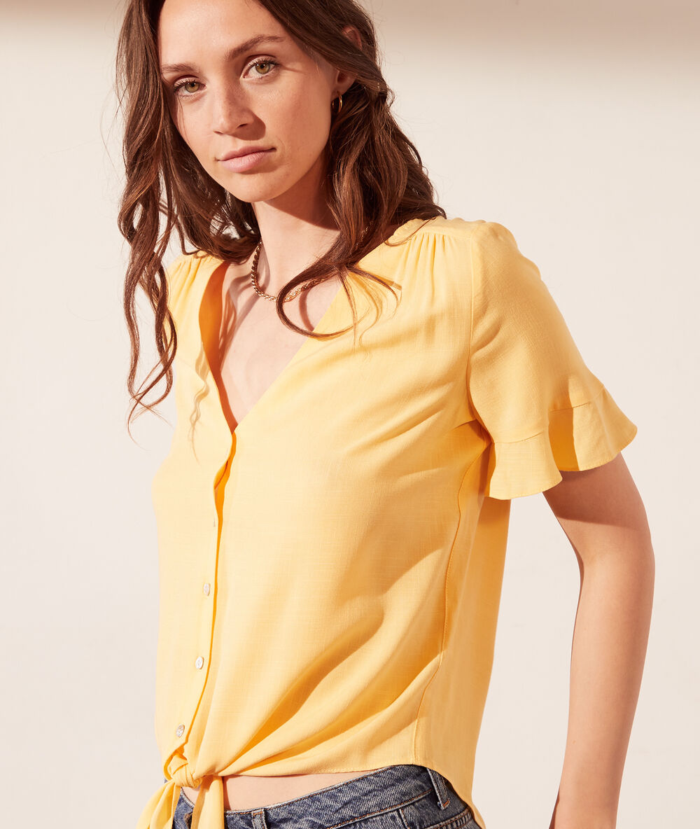 Chemise à nouer jaune pale.