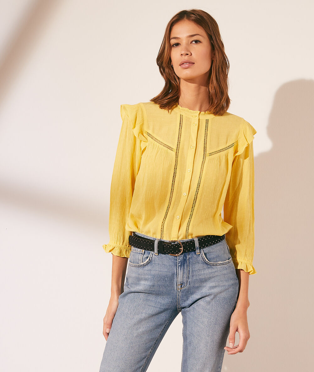 Chemise à volants avec détails en dentelle jaune pale.
