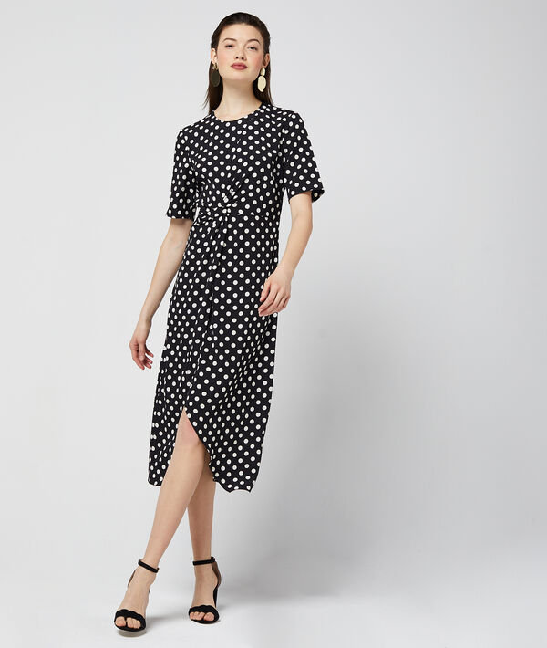 Robe longue drapée à pois noir.